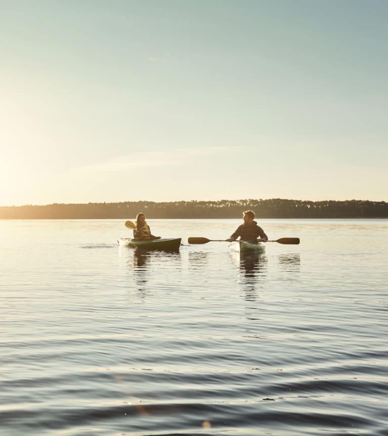 Kanufahren – Pärchen in 1er-Kajaks auf dem See