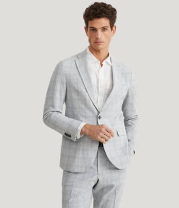 A man wearing a glen check patterned suit.