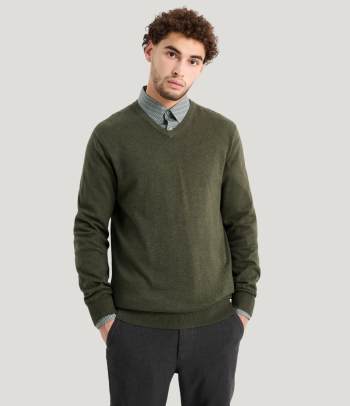 A casual office Christmas party outfit with a smart shirt and fine knit jumper.