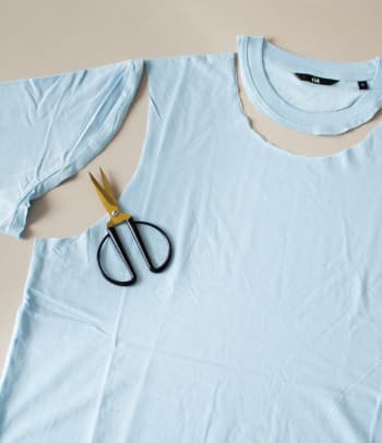 Upcycling a T-shirt: cutting out the sleeves and collar.